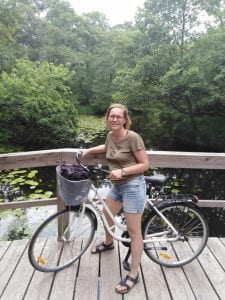 a photo of Matylda and her bicycle in a place with trees